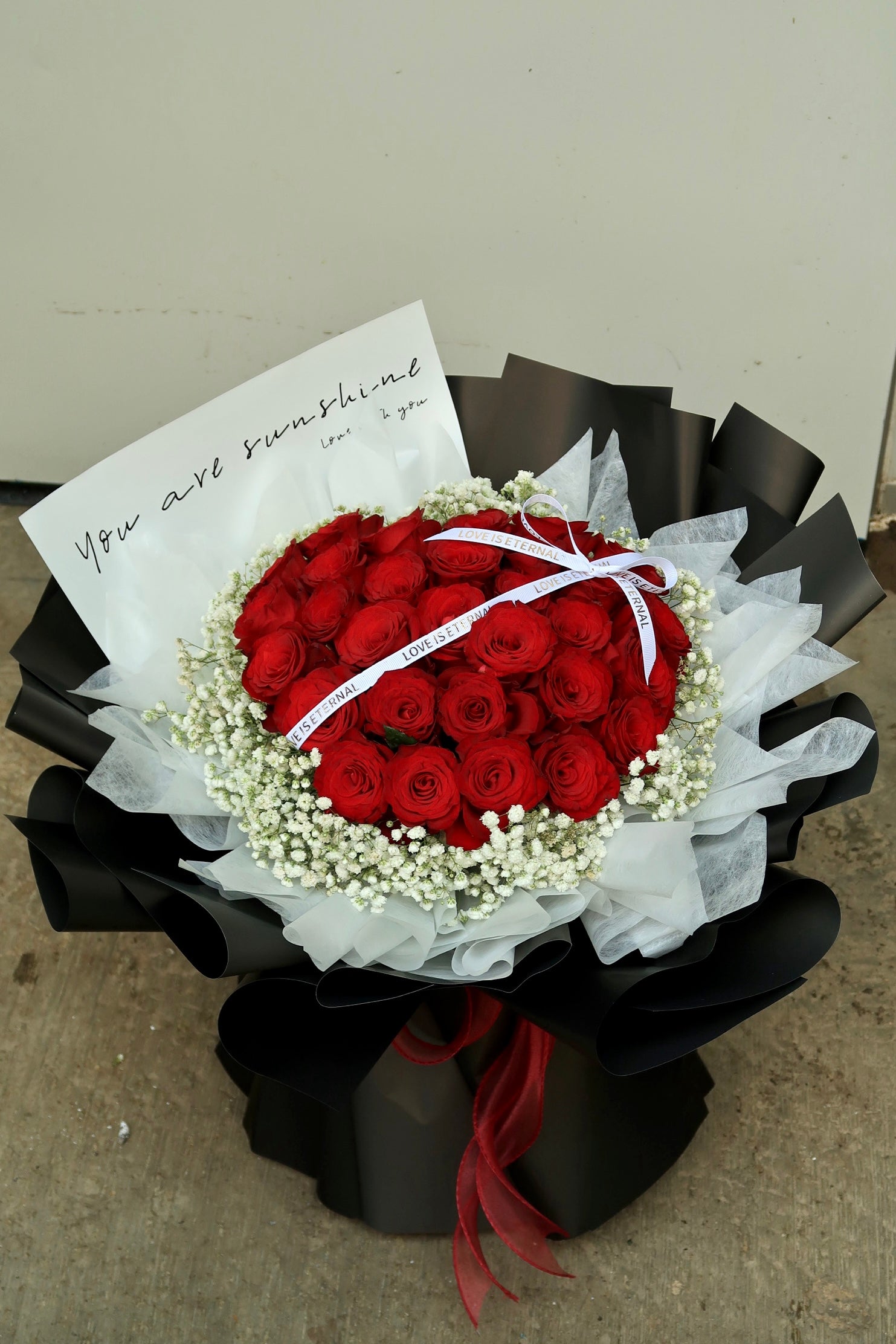 XL red rose bouquet with 35 fresh roses and baby's breath, wrapped in elegant white and black paper. Perfect for Valentine's Day, anniversaries, and romantic gifts. Available for same-day flower delivery in Kuala Lumpur & Selangor.